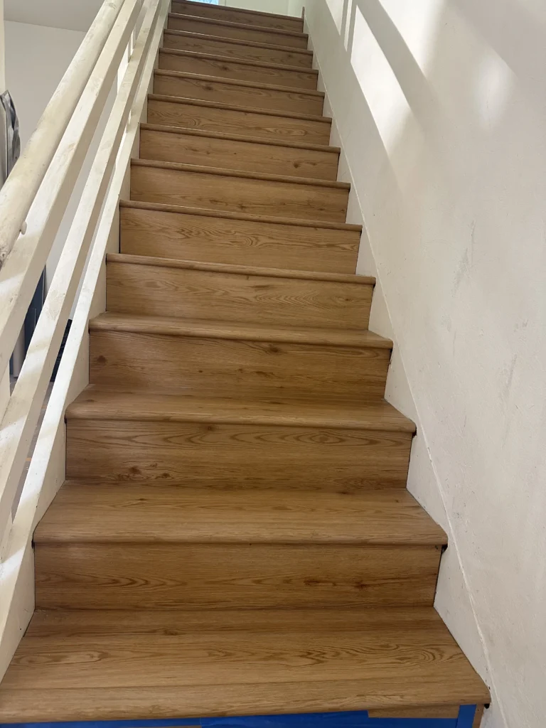 A wooden staircase with white paint on it. deck contractor