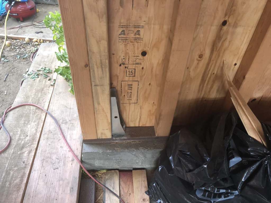 A piece of wood is sitting on the ground next to a trash can siding contractors.